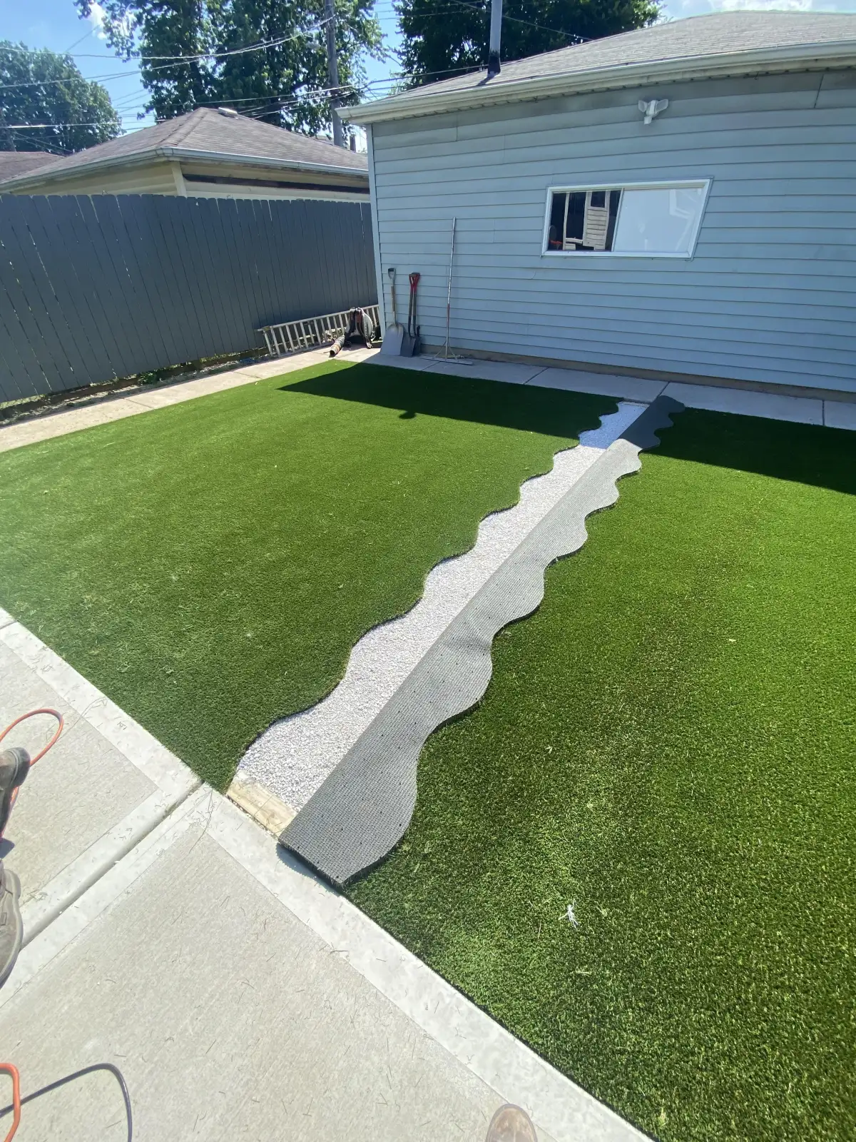 Artificial turf installation in progress on a Michigan residential lawn