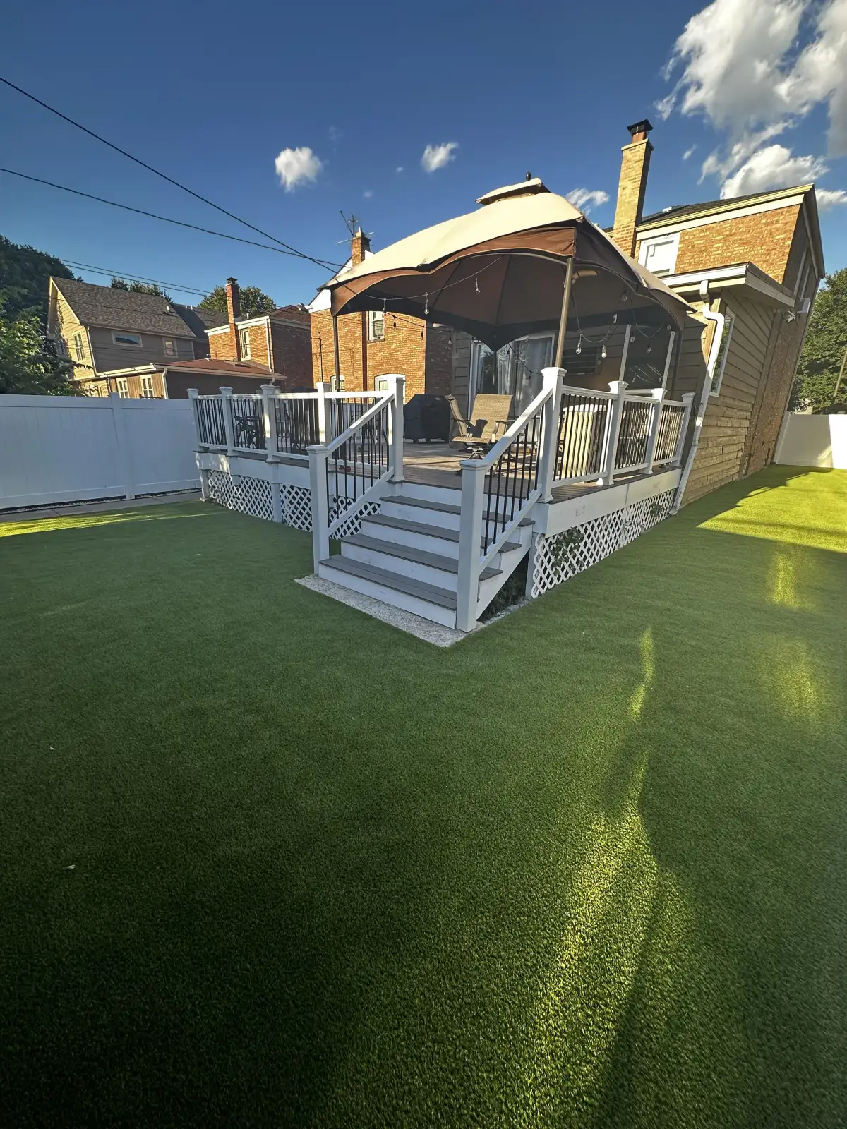 Covered backyard deck overlooking a turf lawn