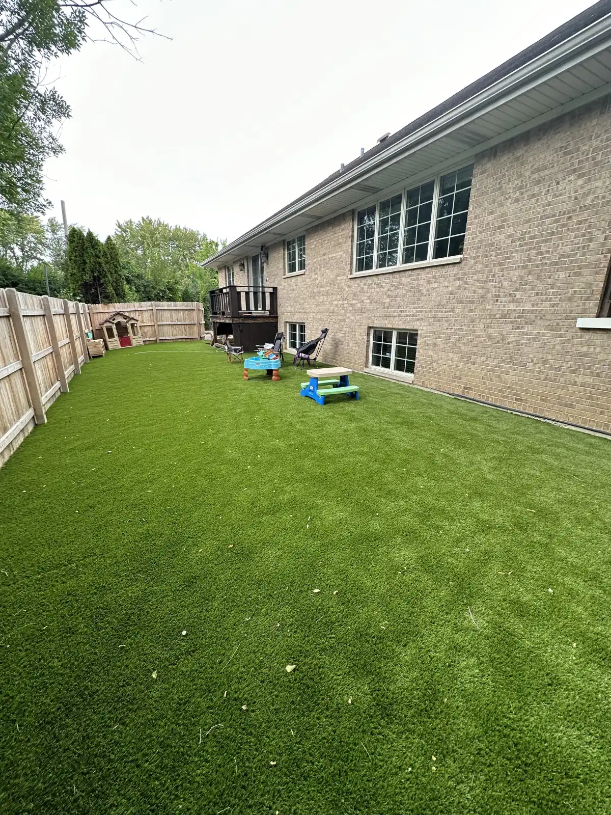 Finished artificial grass lawn beside a Michigan outdoor living area