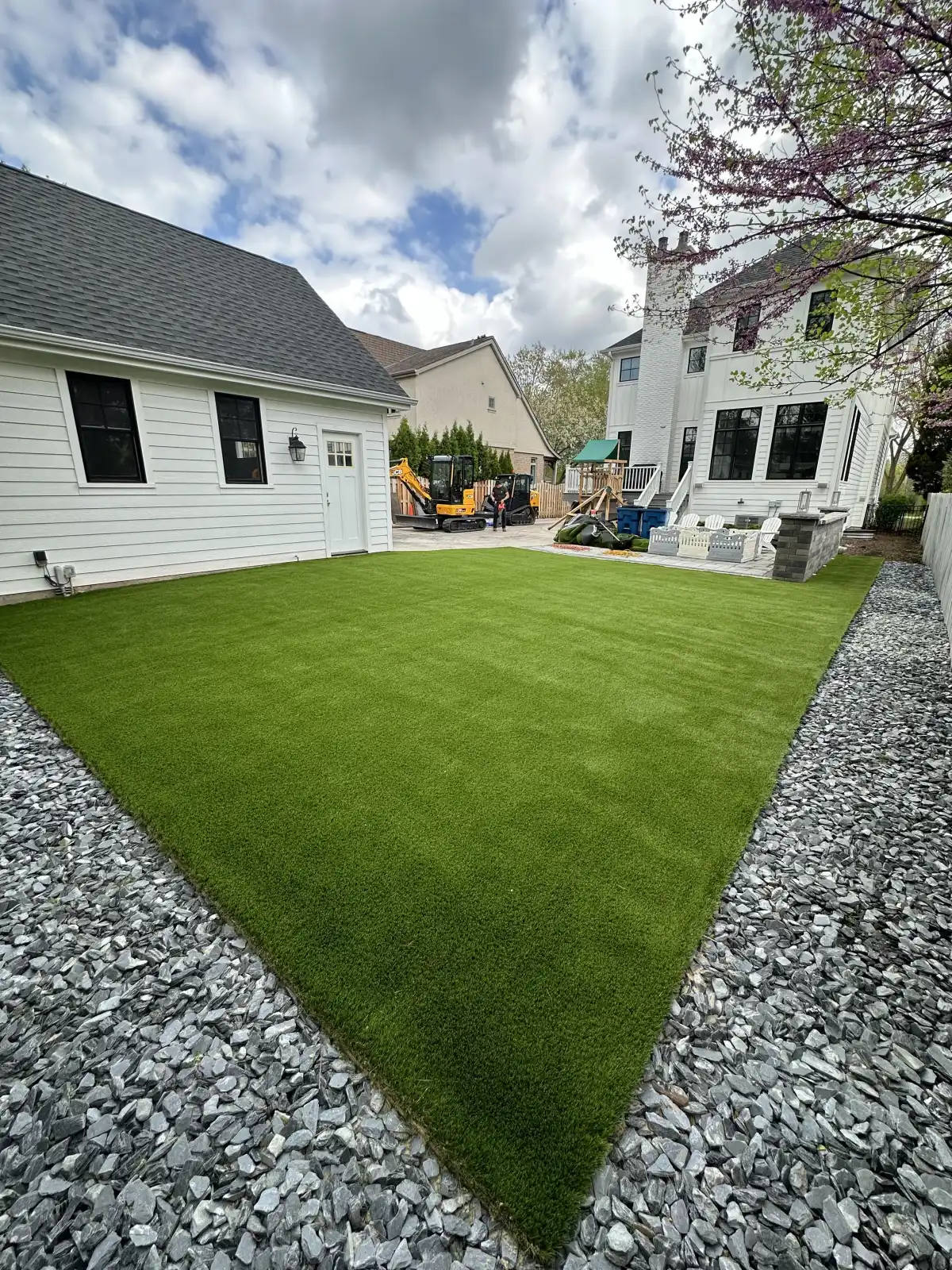 Backyard synthetic turf with retaining wall and play set in Grand Rapids