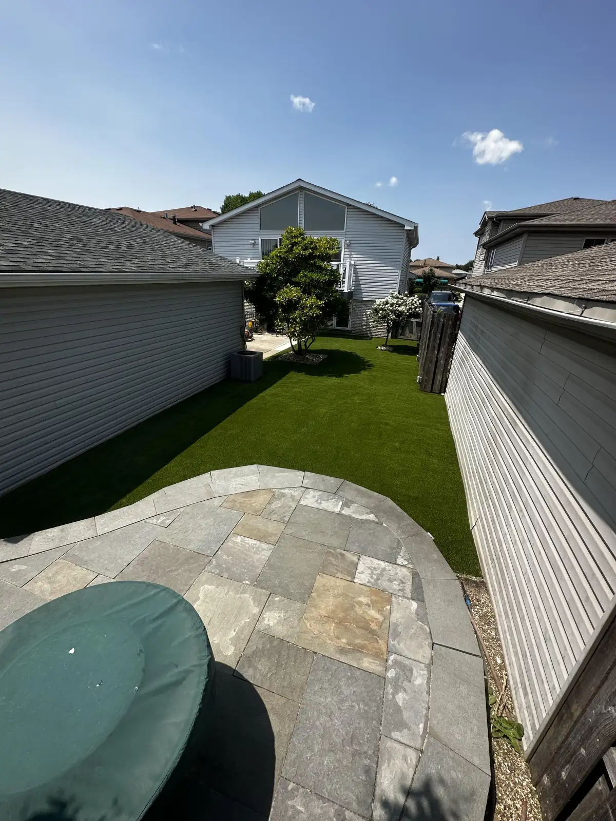 Synthetic turf patio area with hot tub at a Southwest Michigan home